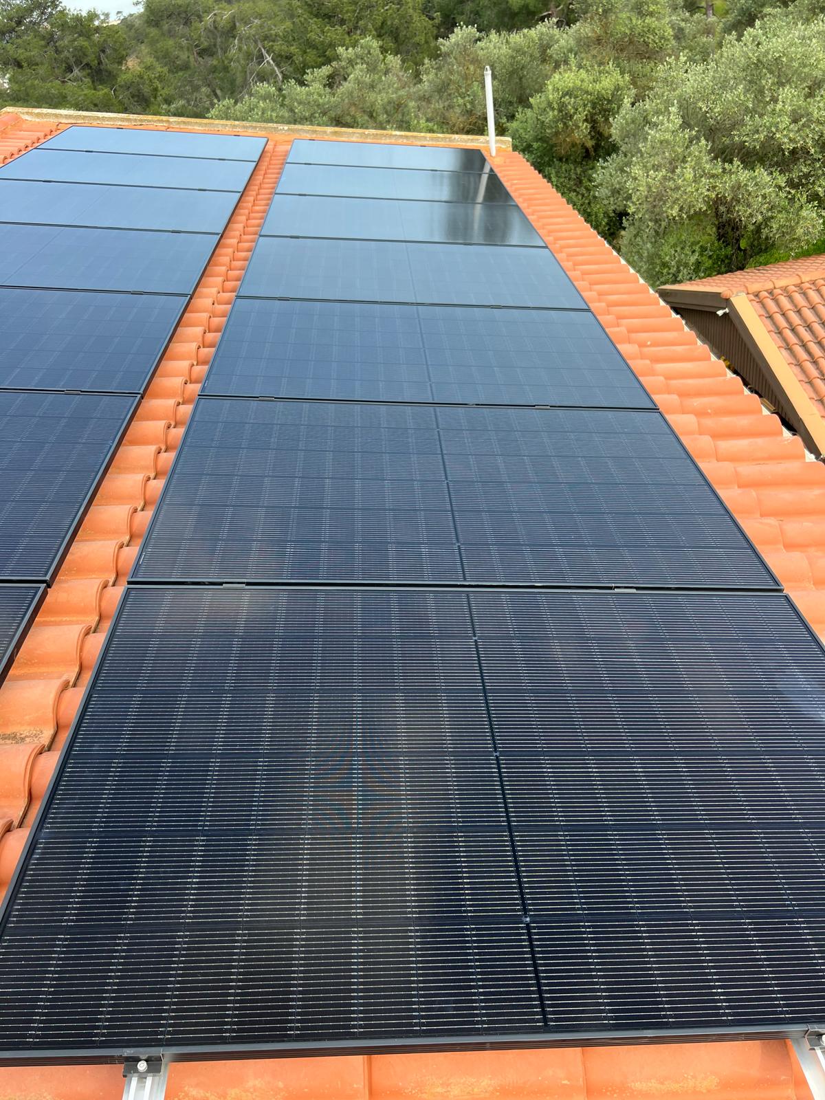 All-black photovoltaic panels mounted on a tiled roof in Paphos
